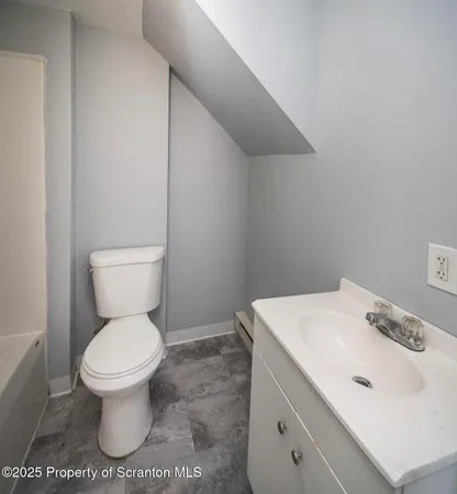 a white toilet sitting next to a bathroom sink