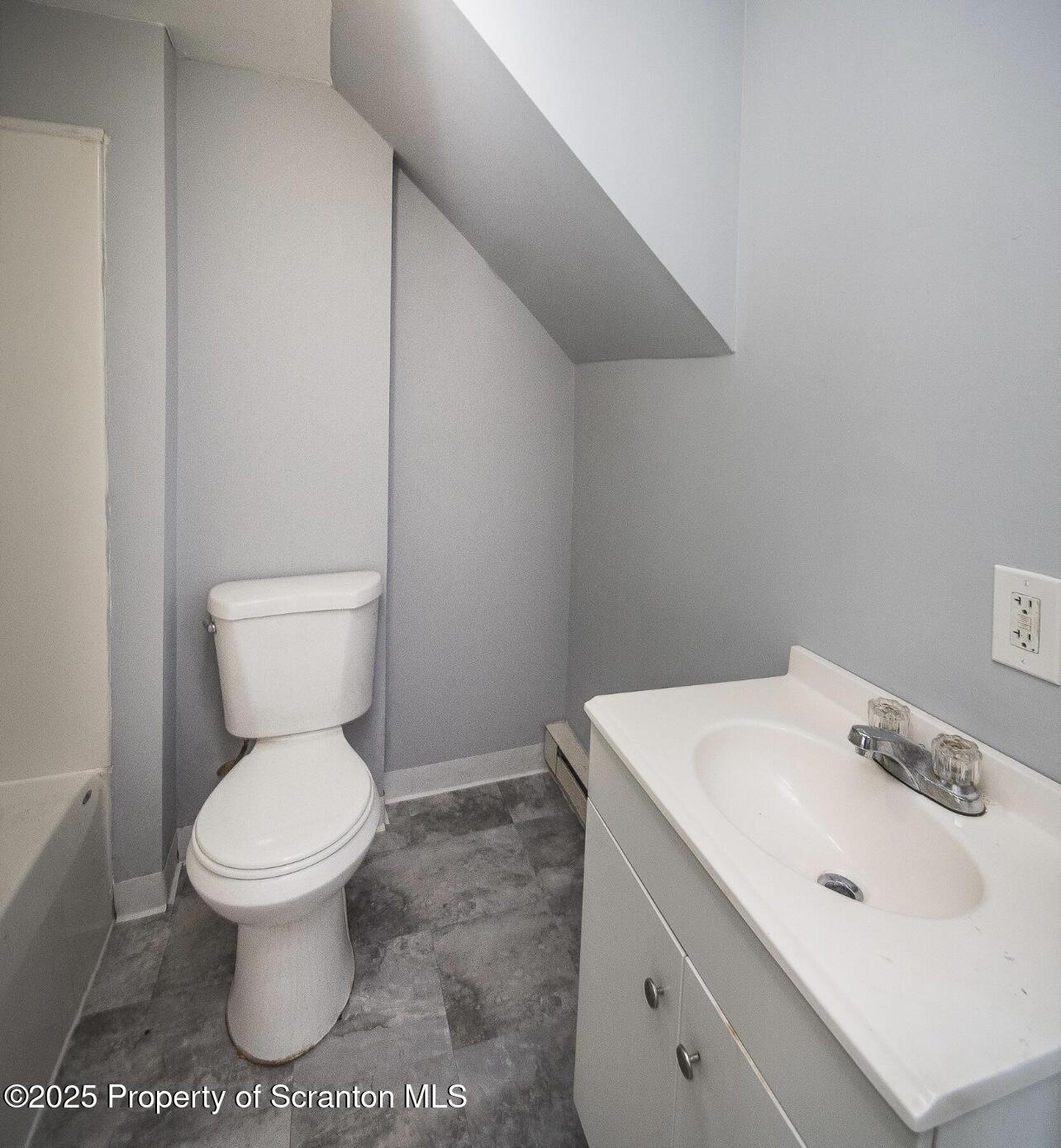 144 Jefferson Street Simpson, PA 18407 - Photo 7 of 14 a white toilet sitting next to a bathroom sink
