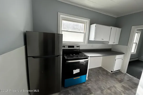 a white refrigerator freezer and a stove sitting inside of a kitchen