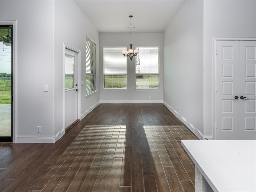 2108 Charters Circle Nevada, TX 75173 - Photo 15 of 37 Unfurnished dining area with dark wood-style flooring and a chandelier