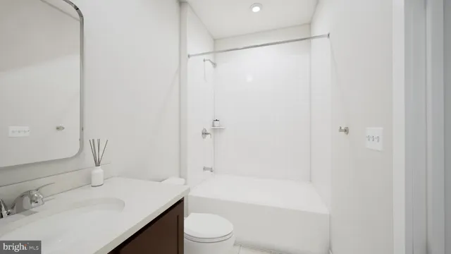 a bathroom with a bathtub shower sink vanity and toilet