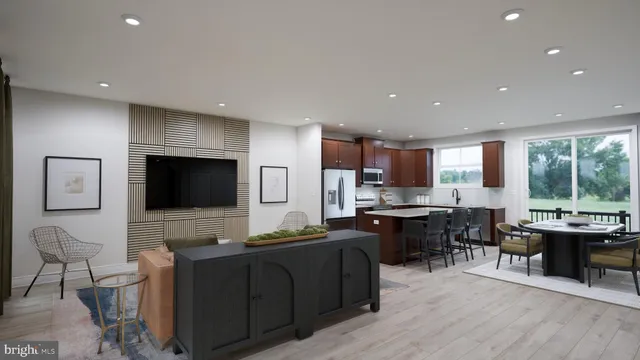 a living room with furniture a flat screen tv and kitchen view