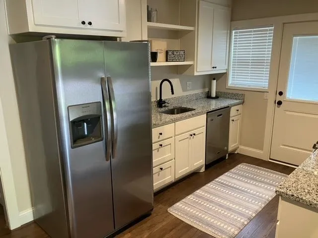 a kitchen with stainless steel appliances granite countertop a refrigerator and a sink