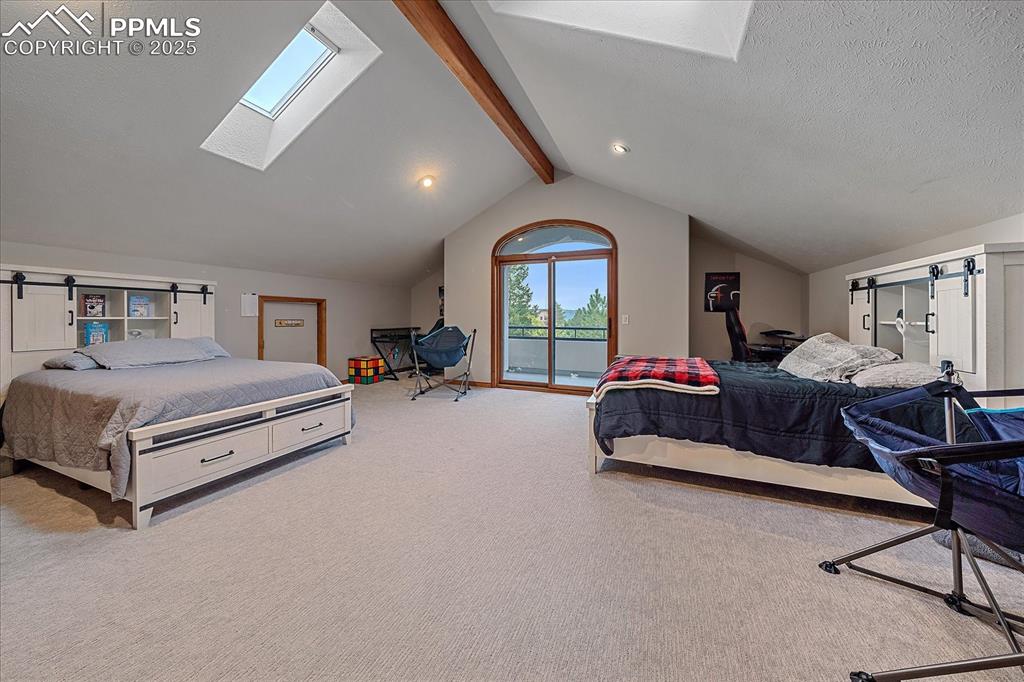 8045 Eagle Road Larkspur, CO 80118 - Photo 25 of 50 a spacious bedroom with a bed and a chandelier