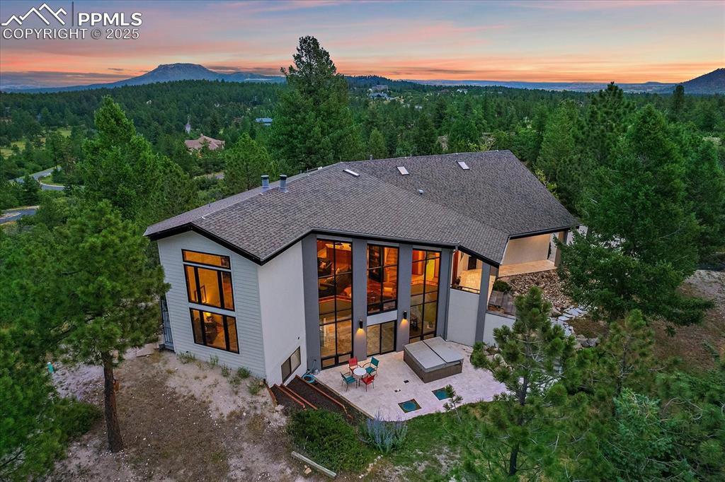 8045 Eagle Road Larkspur, CO 80118 - Photo 41 of 50 a aerial view of a house with table and chairs under an umbrella