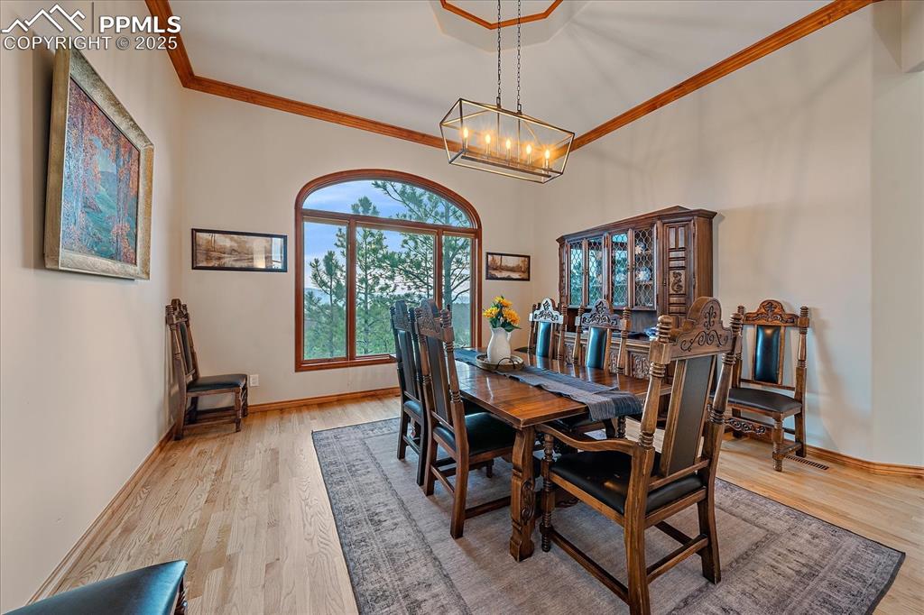 8045 Eagle Road Larkspur, CO 80118 - Photo 10 of 50 a dining room with furniture a chandelier and wooden floor