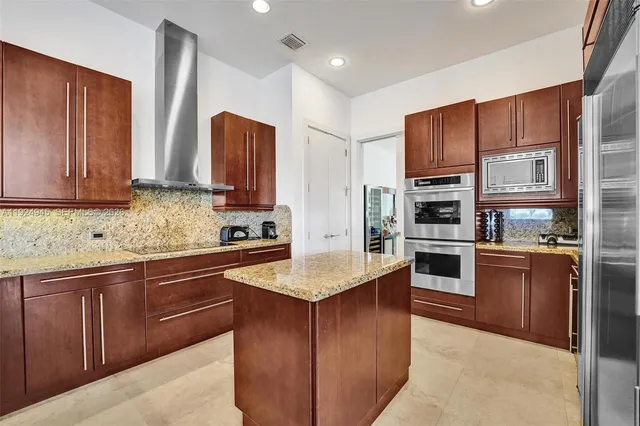 a kitchen with stainless steel appliances granite countertop wooden cabinets a stove top oven a sink and dishwasher