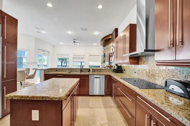a kitchen with stainless steel appliances granite countertop a sink a stove and a refrigerator