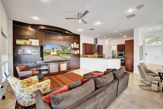 a living room with furniture kitchen view and a large window