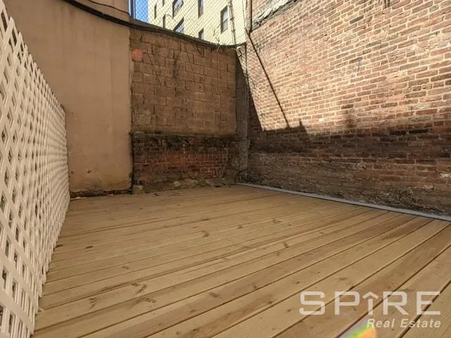 an empty room with wooden floor and window