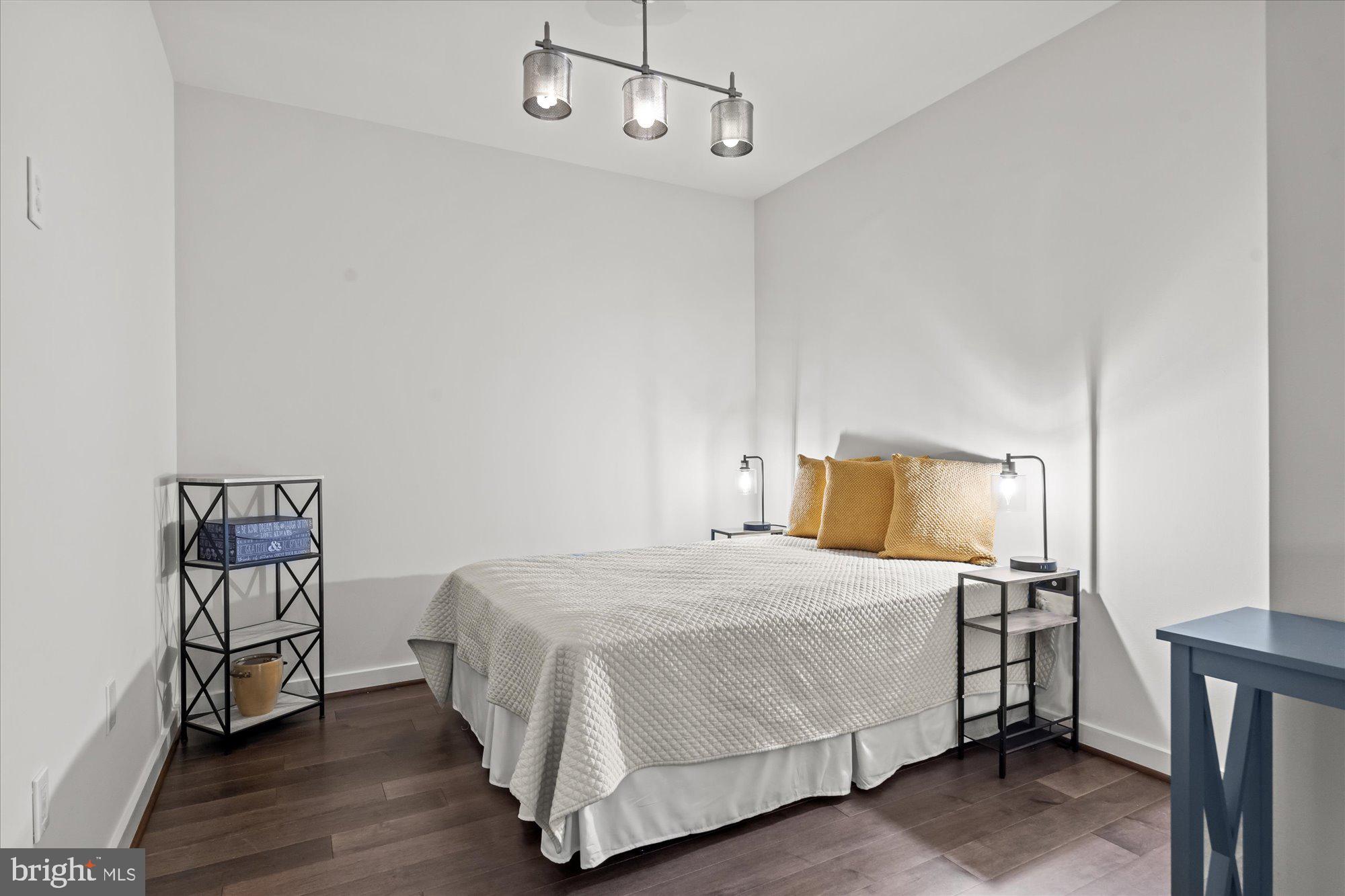 1025 First Street Southeast, Unit 511 Washington, DC 20003 - Photo 11 of 25 a bedroom with a bed a rug and wooden floor