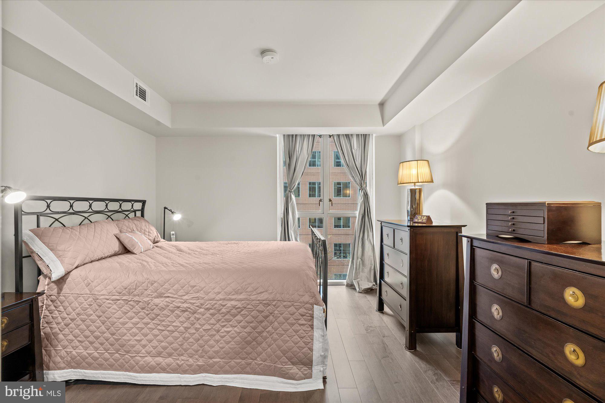 1025 First Street Southeast, Unit 511 Washington, DC 20003 - Photo 7 of 25 a bedroom with a bed furniture and a flat screen tv