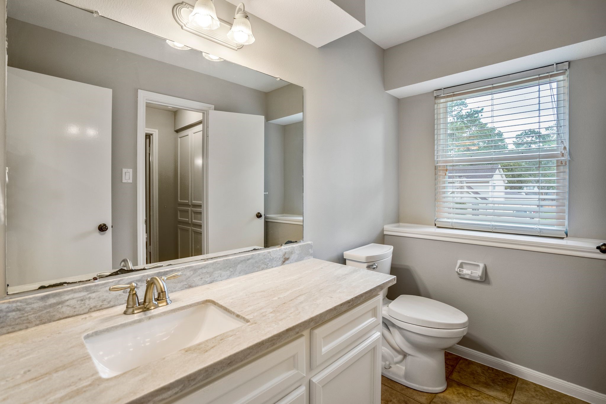 7607 Wycomb Lane Houston, TX 77070 - Photo 29 of 38 a bathroom with a granite countertop sink a toilet and a mirror