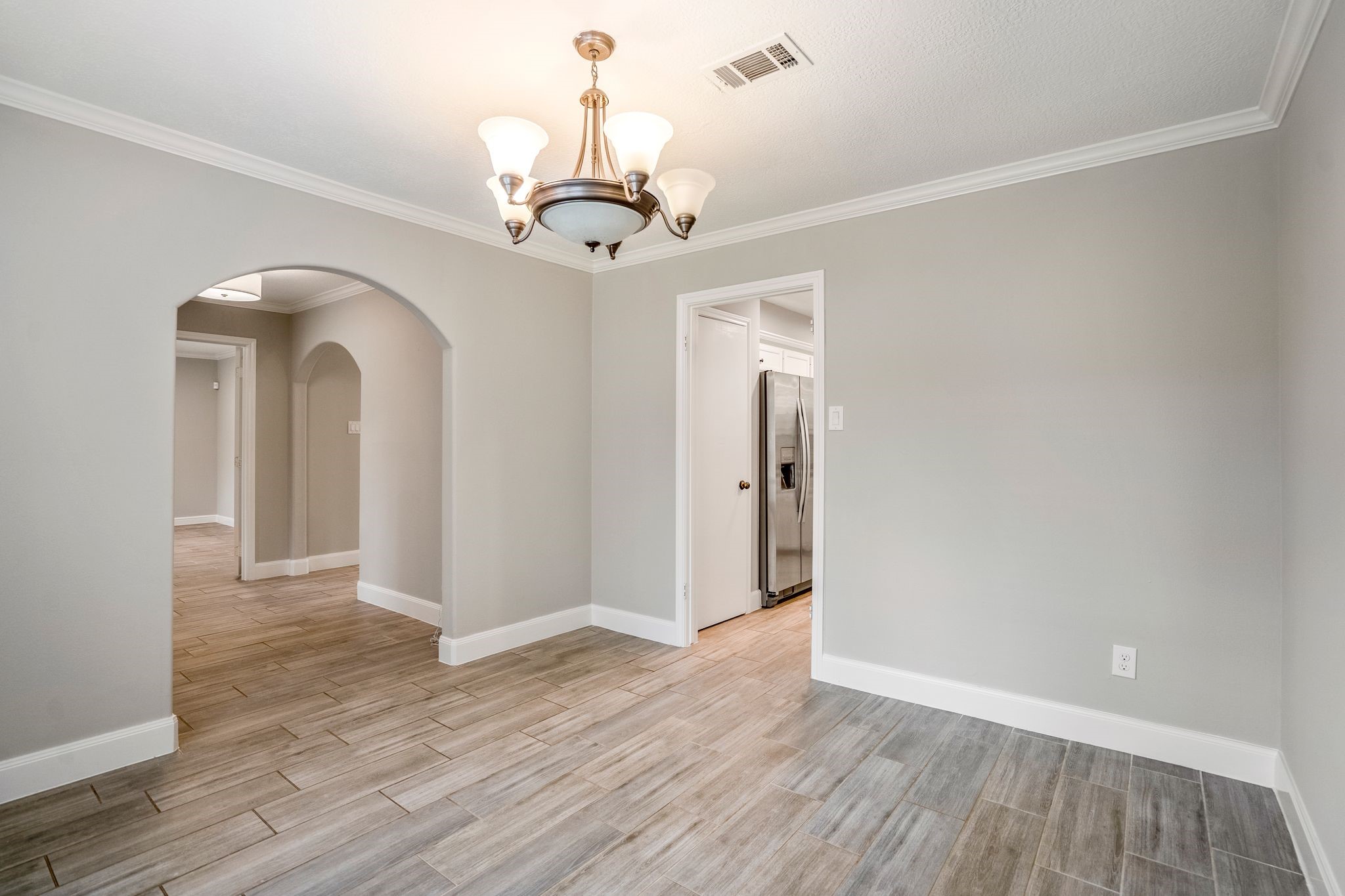 7607 Wycomb Lane Houston, TX 77070 - Photo 8 of 38 a view of a hallway with wooden floor and chandelier