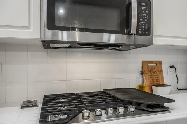 a close view of a stove a microwave and cabinets