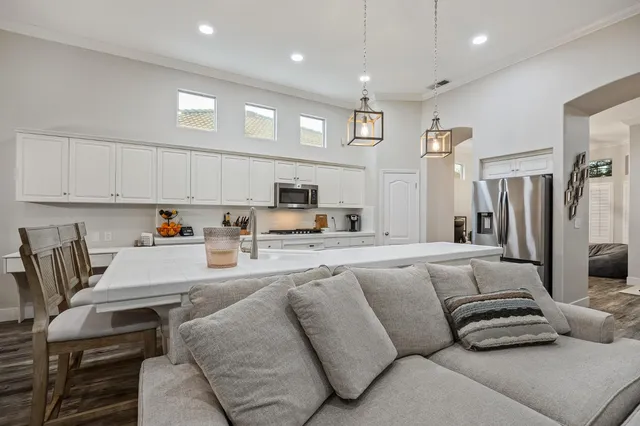 a kitchen with stainless steel appliances granite countertop a sink a stove and refrigerator