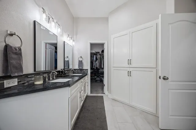 a bathroom with double sink and a mirror