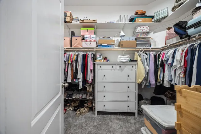 a view of walk in closet with clothes and shoes