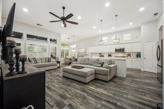 a living room with furniture kitchen area and a window