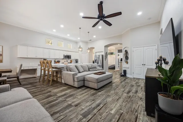 a living room with furniture kitchen view and a potted plant