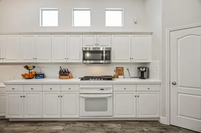 a kitchen with white cabinets and white appliances