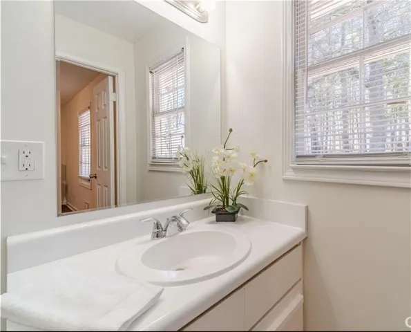 a bathroom with a granite countertop sink and a mirror