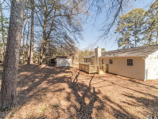 a backyard of a house with table and chairs