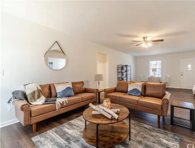 a living room with furniture a rug and a window