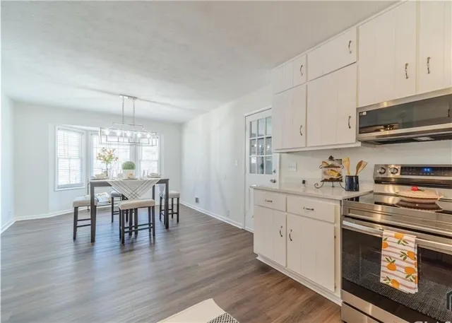 a kitchen with a table chairs stove and cabinets