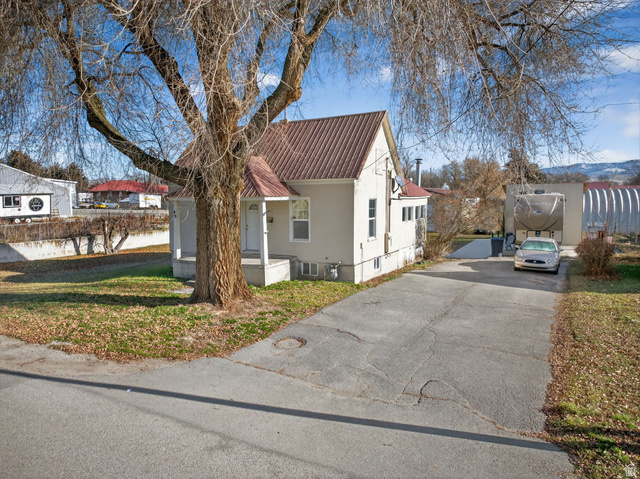 49 South 4th W Street Preston, ID 83263 - Photo 34 of 48 View of home's exterior featuring a metal roof, a porch, asphalt driveway, and a yard