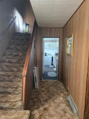 a view of a hallway with a livingroom and stairs