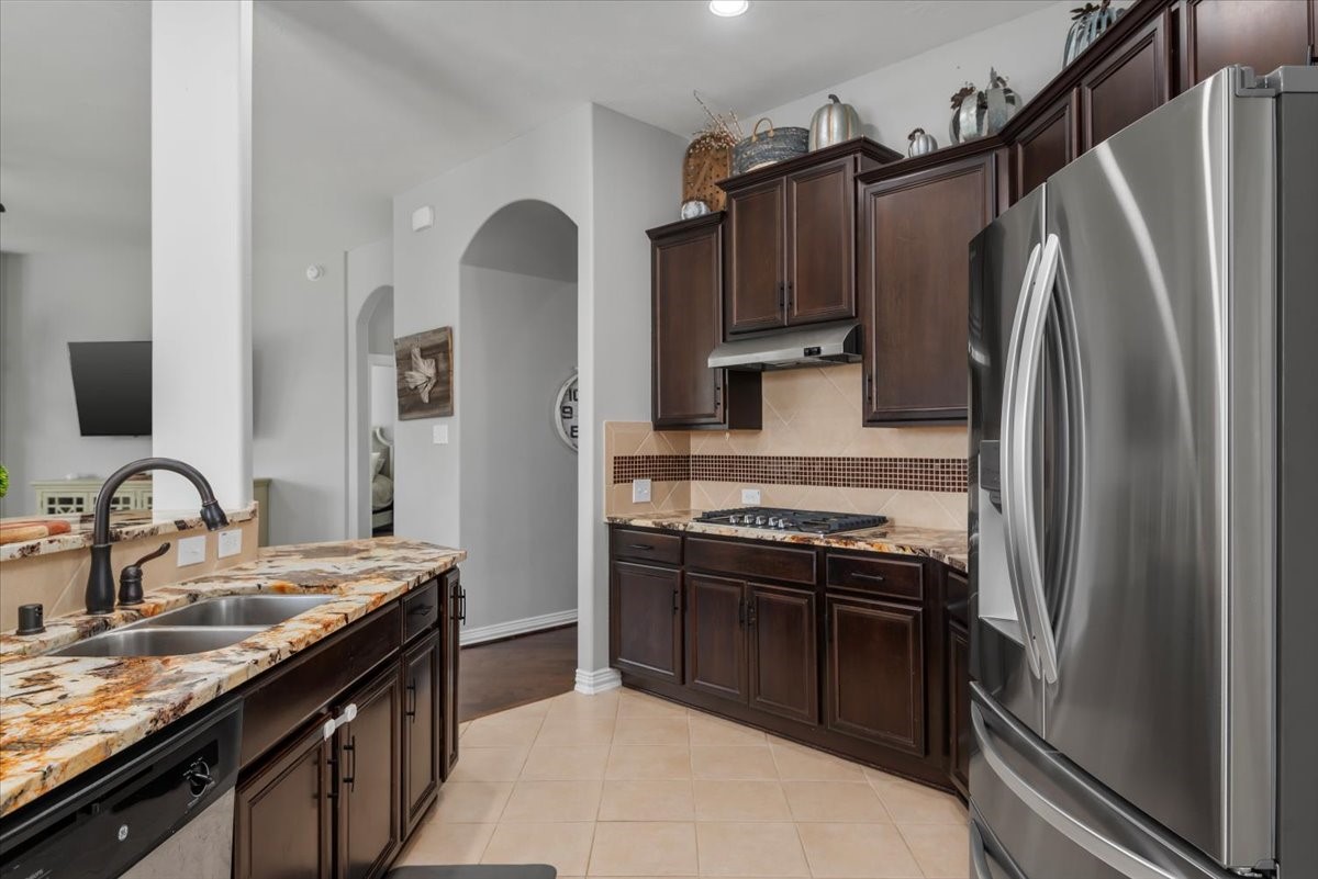 16319 Denise Terrace Drive Hockley, TX 77447 - Photo 16 of 49 a kitchen with granite countertop a refrigerator stove and sink