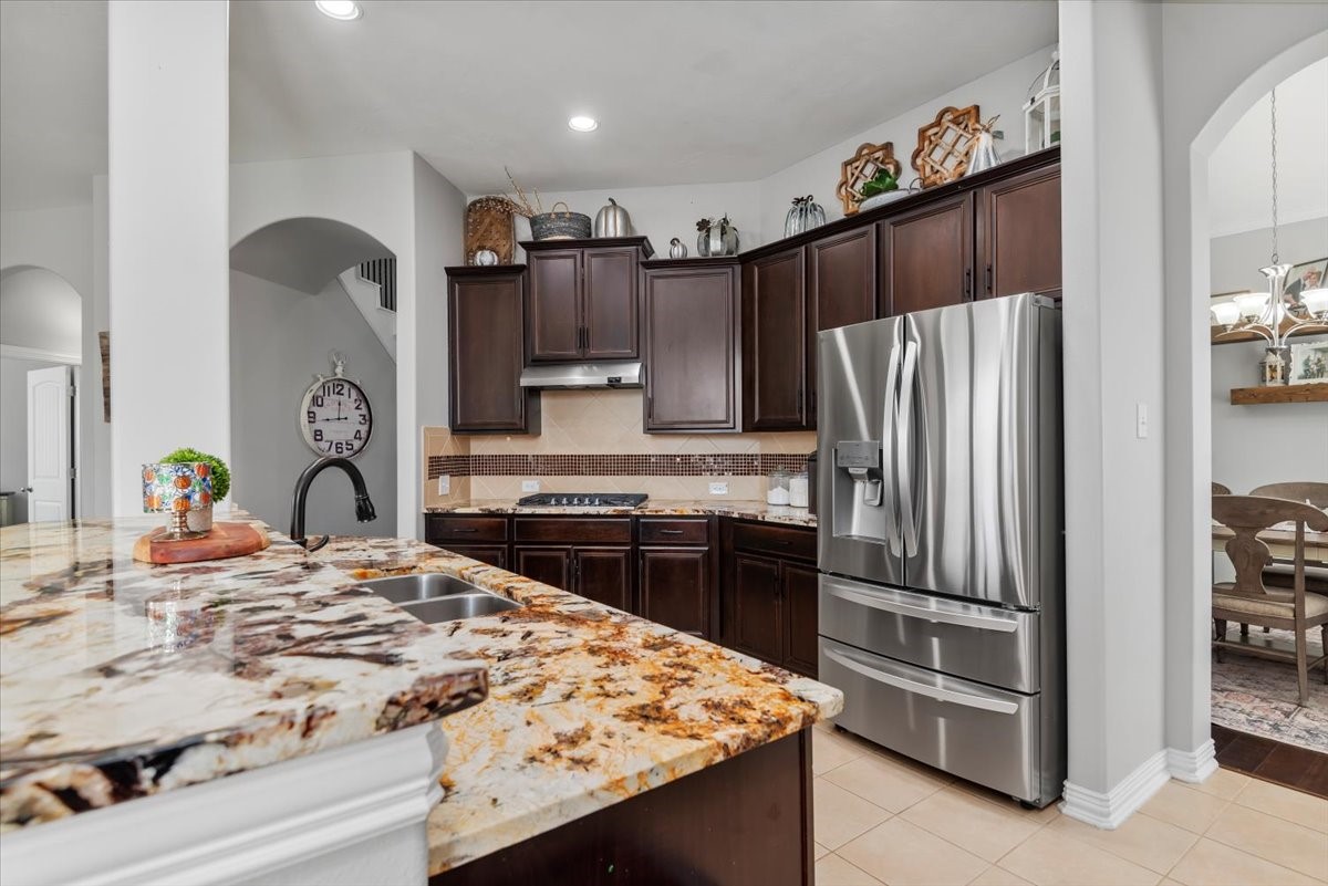 16319 Denise Terrace Drive Hockley, TX 77447 - Photo 17 of 49 a kitchen with kitchen island a refrigerator stove and sink