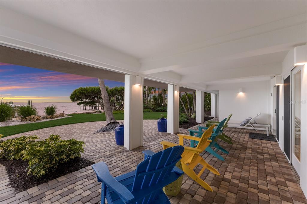 641 Boca Bay Drive Boca Grande, FL 33921 - Photo 38 of 74 a view of a patio with table and chairs potted plants with wooden floor and fence