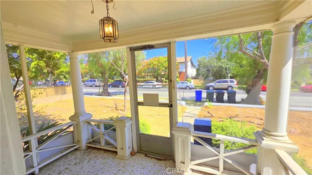 a view of an empty room with wooden floor and furniture