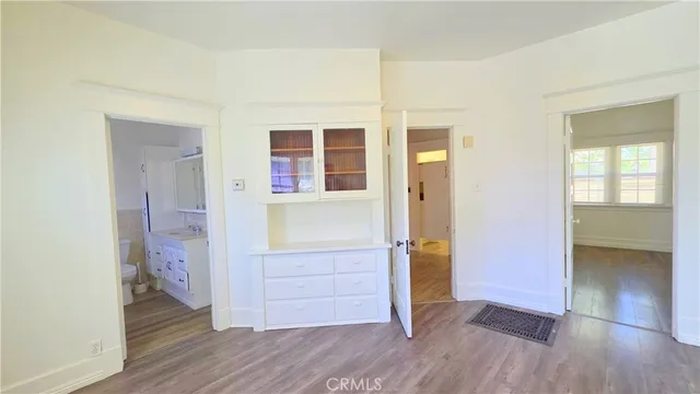 an empty room with wooden floor and entrance