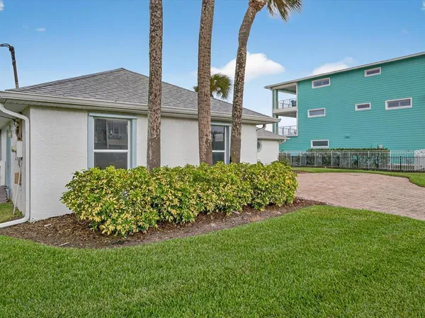 a view of a house with a big yard and potted plants