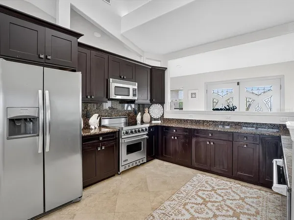 a kitchen with stainless steel appliances granite countertop a refrigerator and a stove