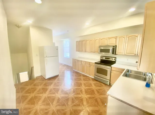 a kitchen with granite countertop a sink a counter top space appliances and cabinets