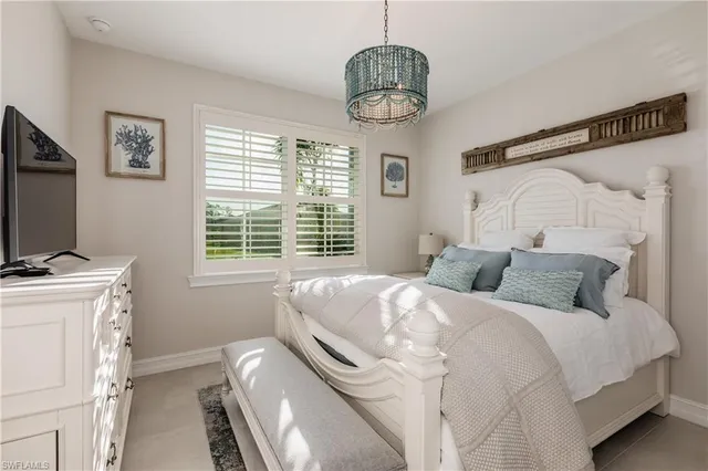 a bedroom with a bed and a chandelier