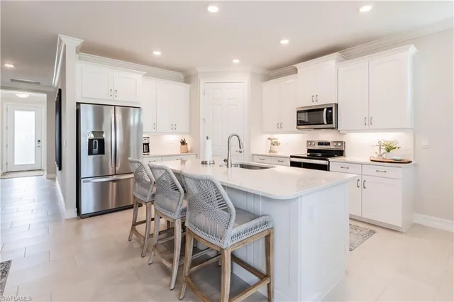 a kitchen with kitchen island a refrigerator stove and microwave