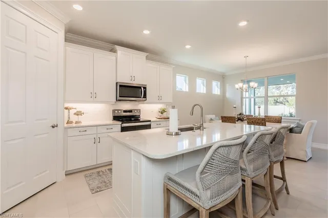 a kitchen with a dining table chairs and refrigerator