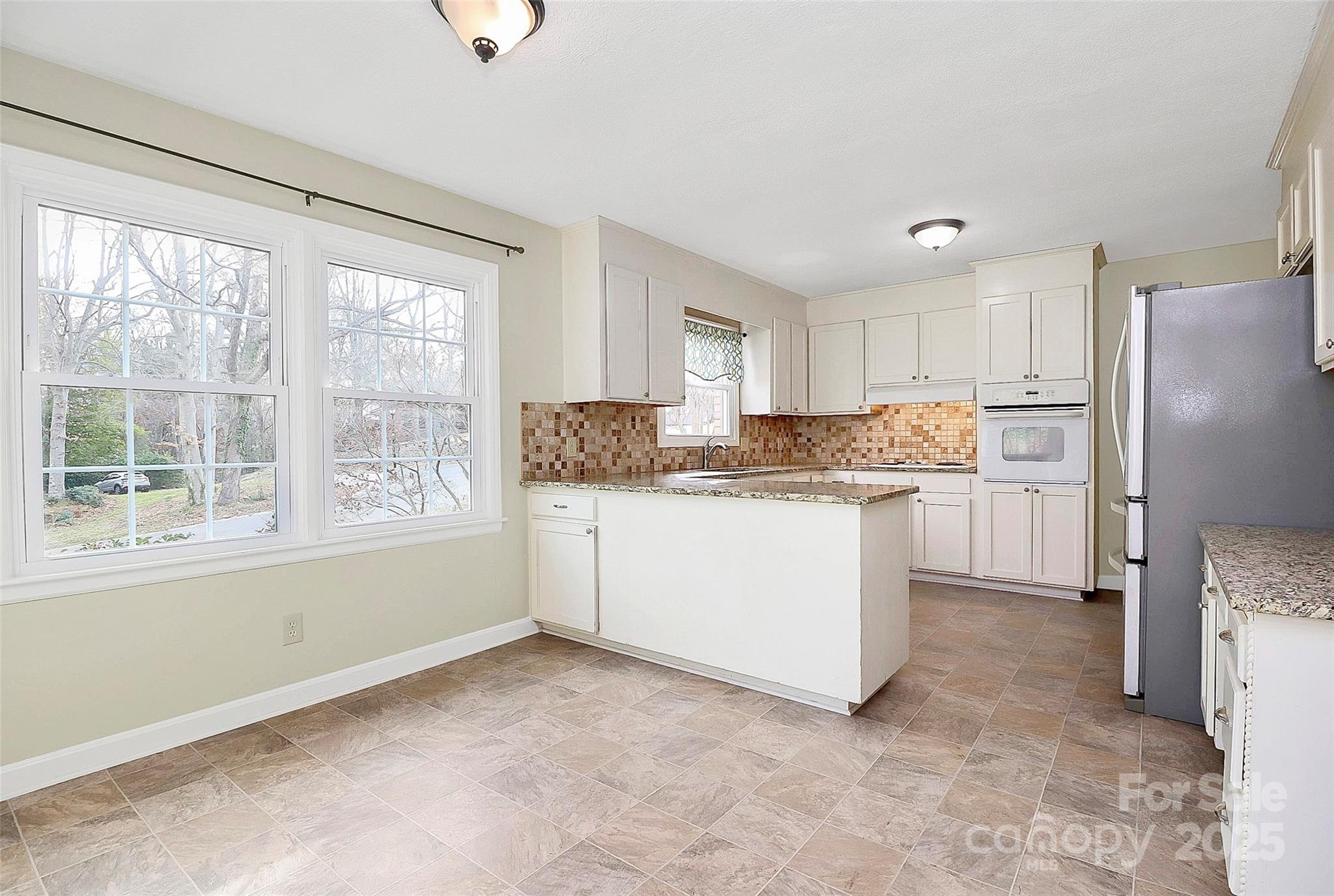 3200 Highview Road Charlotte, NC 28210 - Photo 12 of 48 a kitchen with a refrigerator a stove top oven and white cabinets