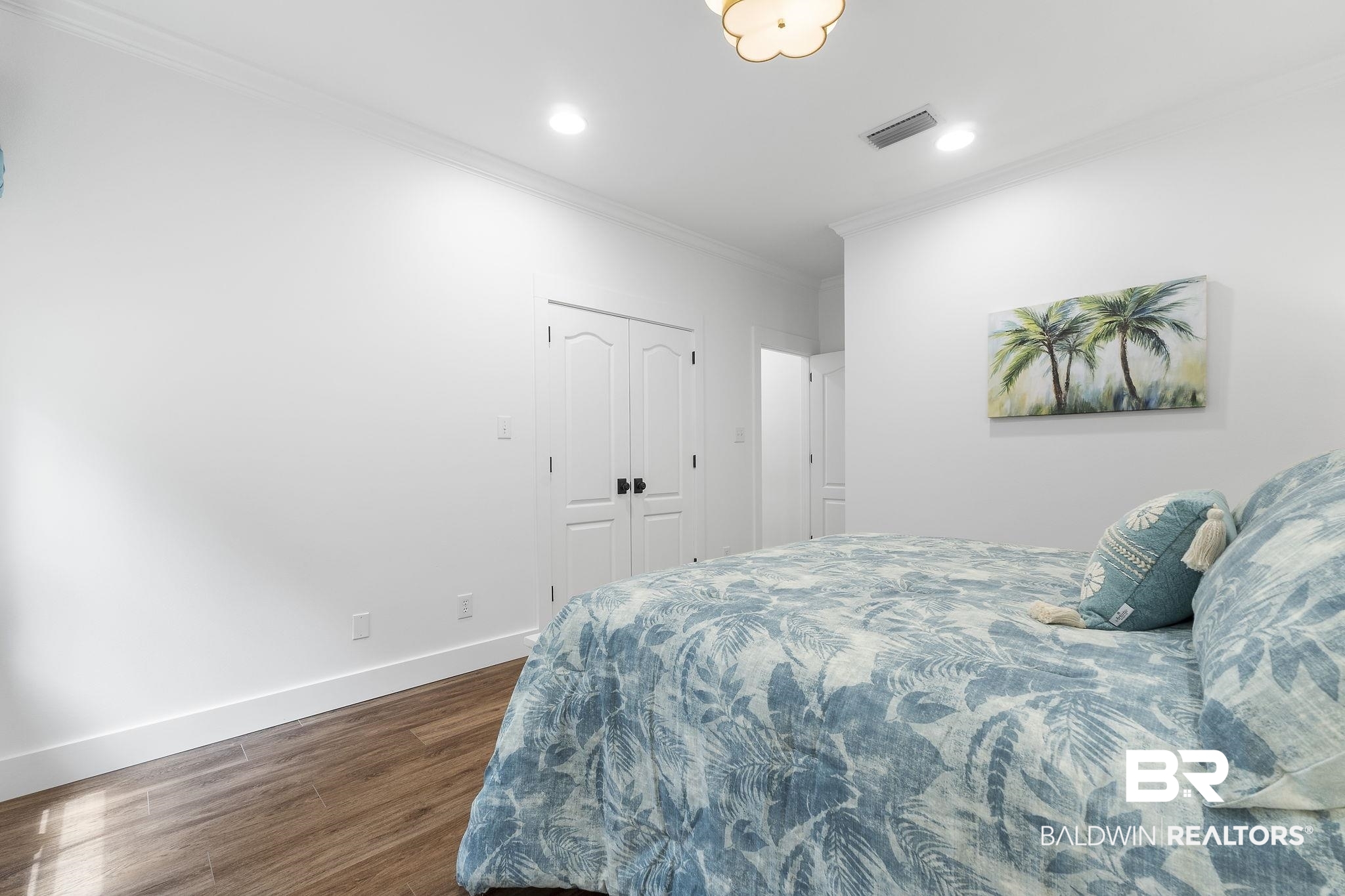 4451 Millhouse Road Gulf Shores, AL 36542 - Photo 39 of 50 Bedroom featuring crown molding, hardwood / wood-style flooring, and a closet