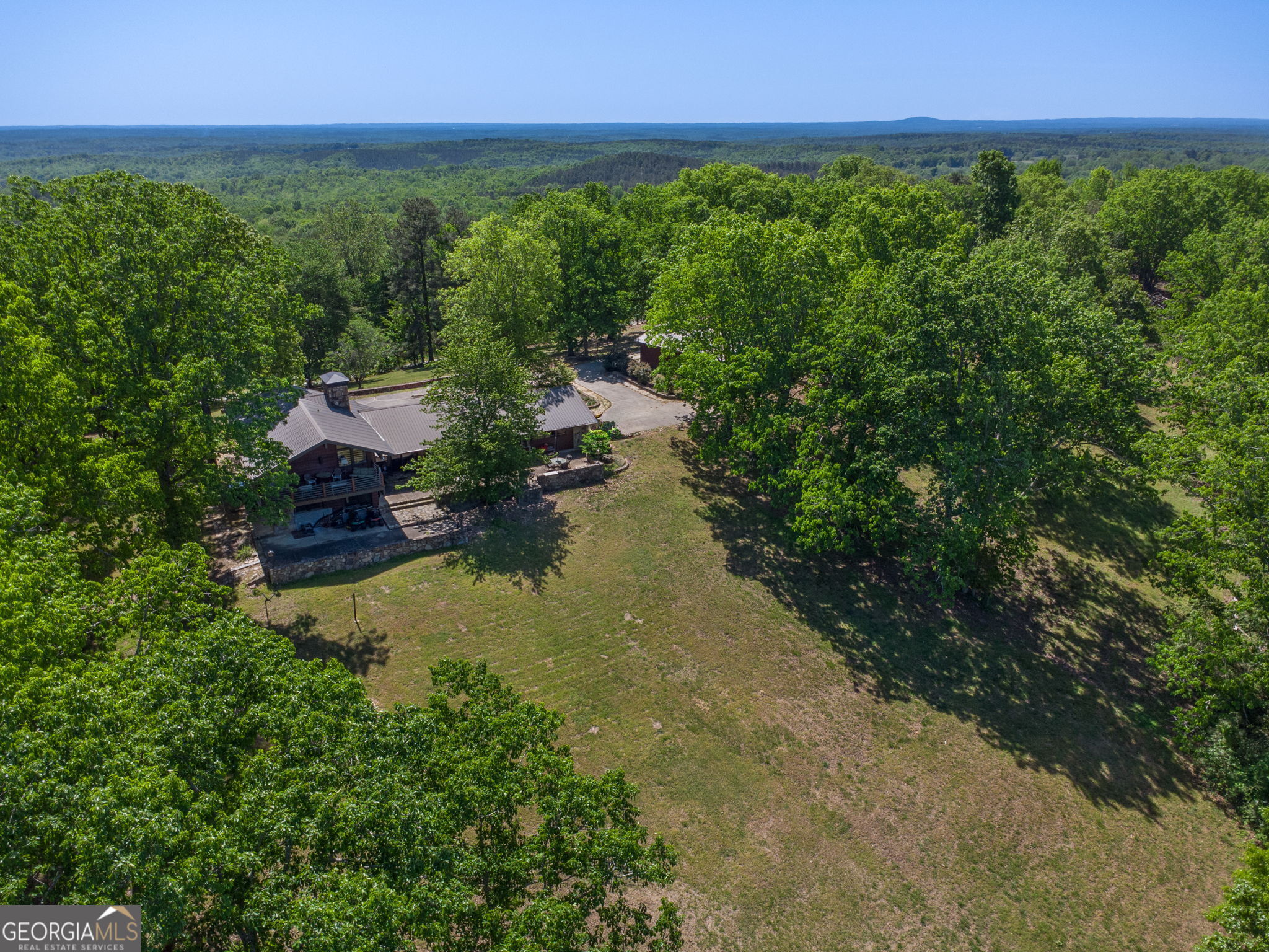 1509 High Point Road Bowdon, GA 30108 - Photo 31 of 33 a view of a lake with lawn chairs and large trees