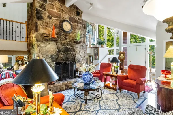 a living room with fireplace furniture and a large window
