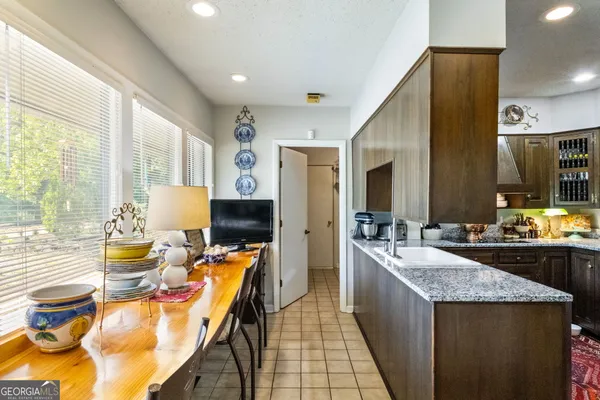 a large kitchen with kitchen island a large window in it