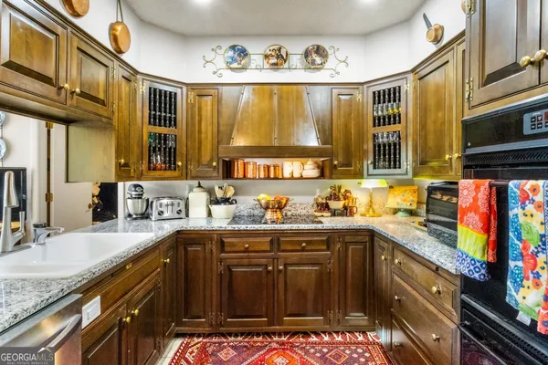 a kitchen with stainless steel appliances granite countertop a sink stove and cabinets