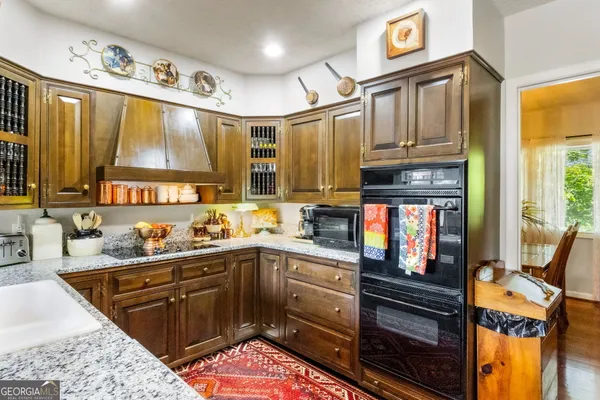 a kitchen with stainless steel appliances kitchen island granite countertop a sink stove and cabinets