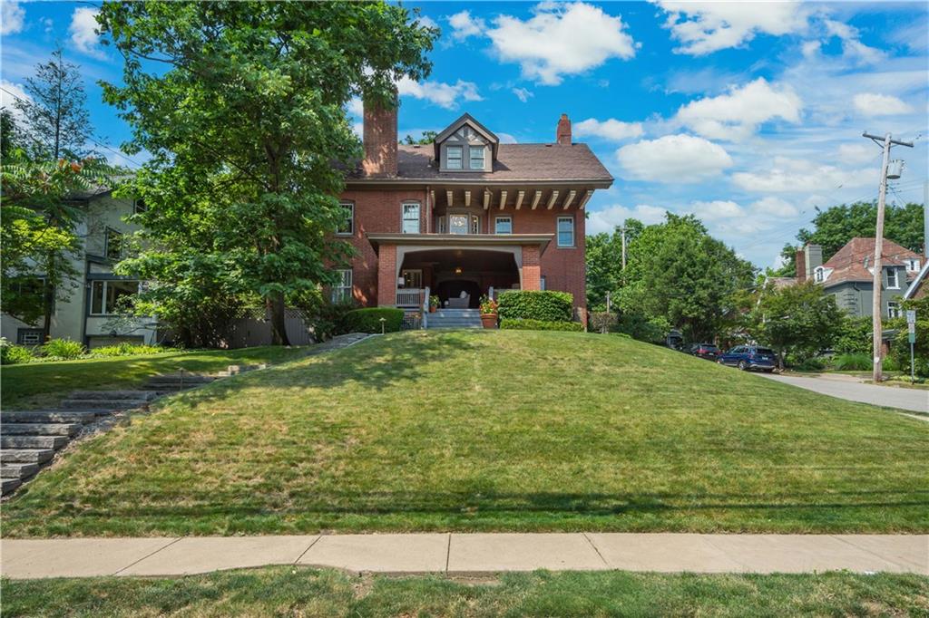 a view of an house with backyard and trees